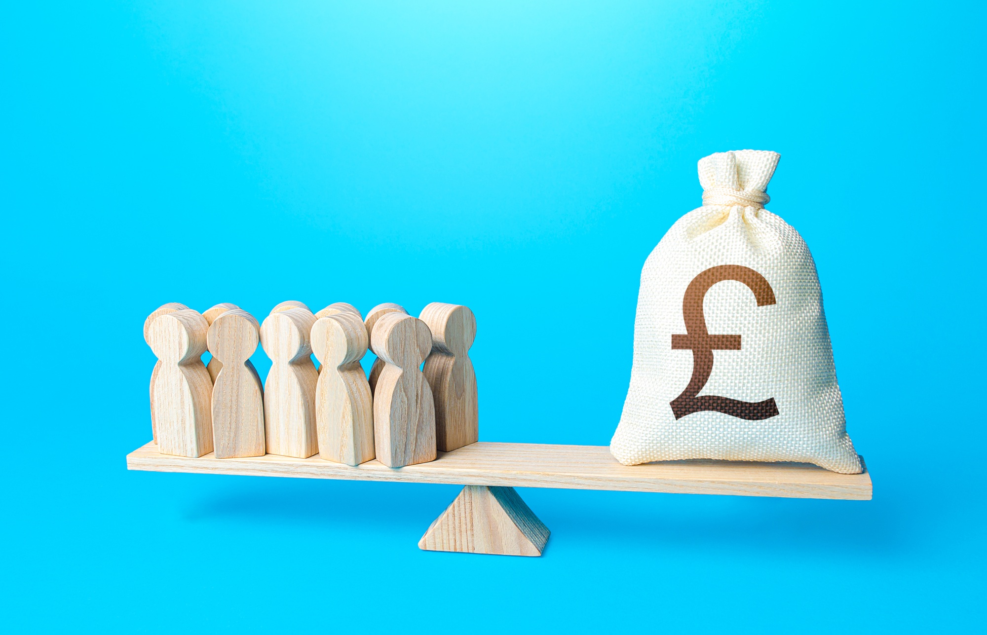 Group of people and british pounds sterling money bag on weight scales.